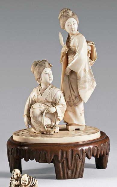 JAPON - Epoque MEIJI (1868-1912) 
Okimono en ivoire, deux jeunes femmes, l'une accroupie...