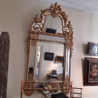null Bevelled mirror in a double frame with a pediment in gilded wood carved with...