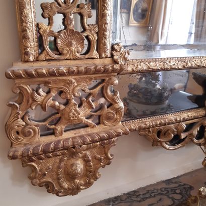 null Bevelled mirror in a double frame with a pediment in gilded wood carved with...