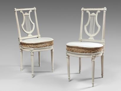 null Pair of white beechwood chairs with a lyre-shaped openwork back. Horseshoe-shaped...