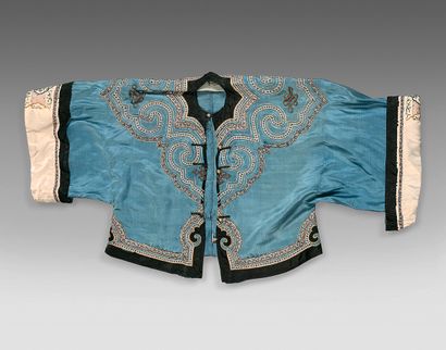 CHINE - Vers 1900 Veste ouvrant par le milieu, en soie bleue, à décor brodé de nuages...