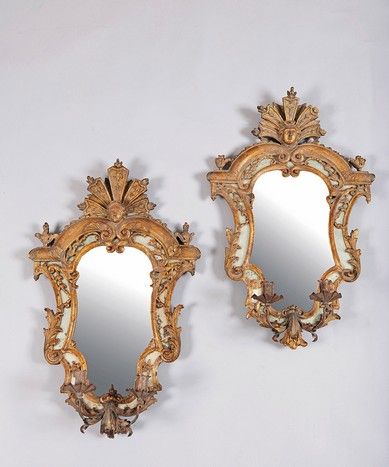 null A pair of sconces with a glass back in a double gilded wood frame carved with...