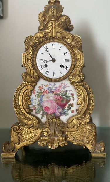 null Clock with rocaille decoration decorated with a polychrome porcelain plate decorated...