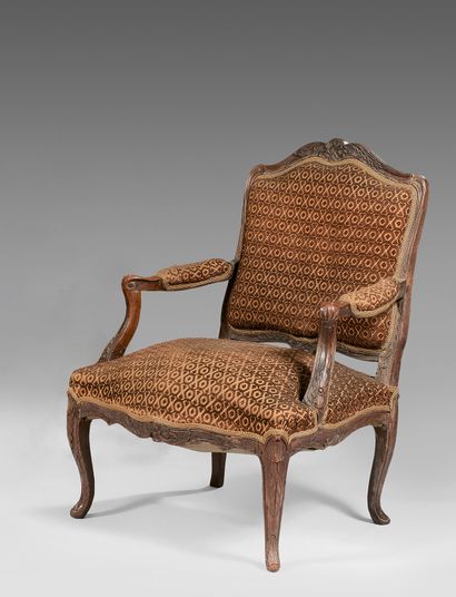 null Armchair with flat curved back in moulded walnut carved with foliage. Armrests...
