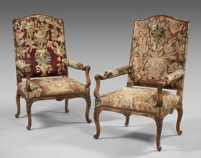null Pair of walnut armchairs with curved flat backs, carved with foliage and lambrequins,...