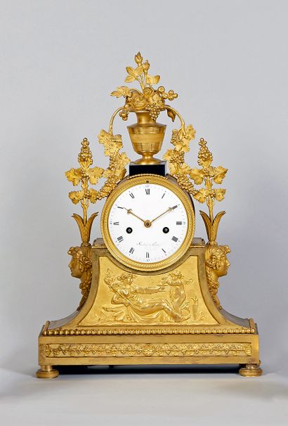 null Gilt bronze clock decorated with a flowering vase and branches of grapes. Enamel...