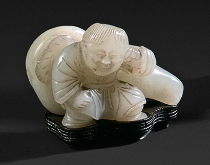 CHINE - XIXe siècle Petit groupe en néphrite sculpté d'un enfant accoudé et adossé...