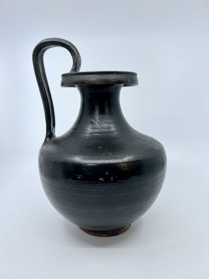 null OENOCHOE with fluted ribbon handle and shouldered belly. Black glazed beige...