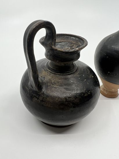 null LOT composed of a bottle and an oenochoe with globular body. Black glazed beige...