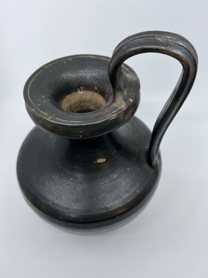 null OENOCHOE with fluted ribbon handle and shouldered belly. Black glazed beige...