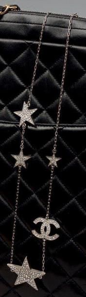 CHANEL Sautoir en métal argenté orné d'étoiles de tailles différentes et d'un si...