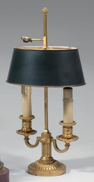 null Petit flambeau à deux lumières en bronze doré. Base ronde à cannelures et feuillages....