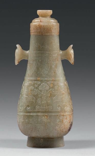  Vase de forme aplatie, en néphrite céladon veiné de rouille, à décor archaïsant...