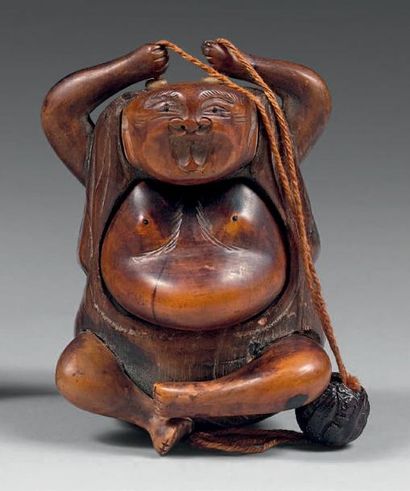 null Tonkotsu en bois en forme de personnage assis, les mains au-dessus de sa tête,...