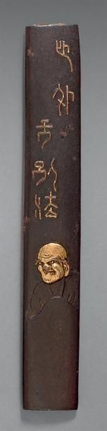 null Kozuka en fer à décor d'écriture sigillaire et de Daruma incrusté en cuivre...