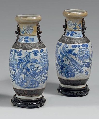  Paire de vases balustres en porcelaine décorée en bleu sous couverte d'un paon parmi...