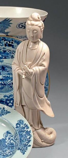  Guanyin en porcelaine émaillée blanc de Chine debout sur les flots, un rouleau d'écritures...