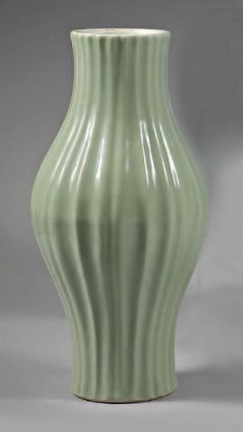CHINE - XVIIIe/XIXe siècle 
Vase de forme balustre à col rétréci et côtelé en porcelaine...