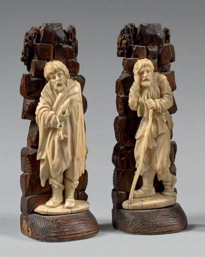 null Deux statuettes d'applique en ivoire sculpté de mendiants adossés à des rochers...