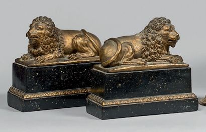 null Deux statuettes de lions couchés en plâtre doré.
Socle à l'imitation du porphyre...