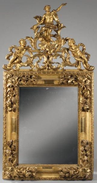 null Grand miroir dans un encadrement surmonté d'un fronton en bois doré à décor...
