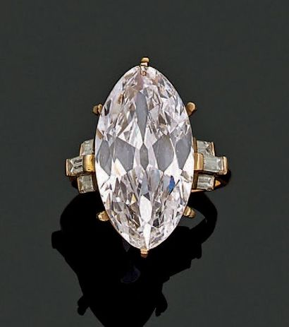 Bague en or jaune 750 millièmes ornée au centre d'un diamant de forme navette et...