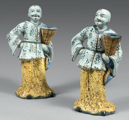 LILLE Paire de statuettes de
Chinois porte-flambeaux debout habillés d'une robe jaune...