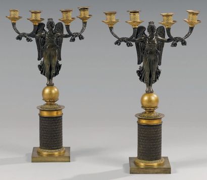 null Paire de candélabres en forme de Victoire ailée en bronze patiné tenant deux...
