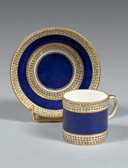 SÈVRES Petite tasse litron et sa sous-tasse, décor polychrome et or d'un fond bleu...