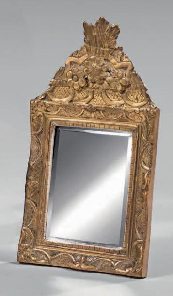 null Petit miroir biseauté dans un encadrement en bois redoré à fronton sculpté de...