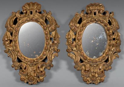 null Paire de petits miroirs ovales dans des encadrements en bois doré ajouré sculptés...