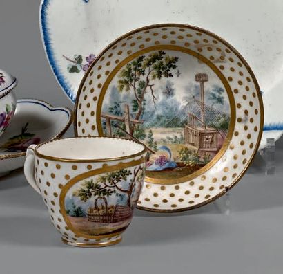 SÈVRES Tasse et sa sous-tasse, décor polychrome et or au centre de paysages de jardin...