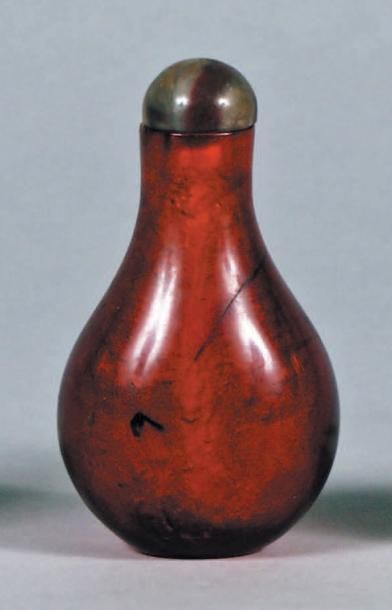 CHINE - XXe siècle Flacon tabatière de forme bouteille à panse basse en ambre.
(Égrenures,...