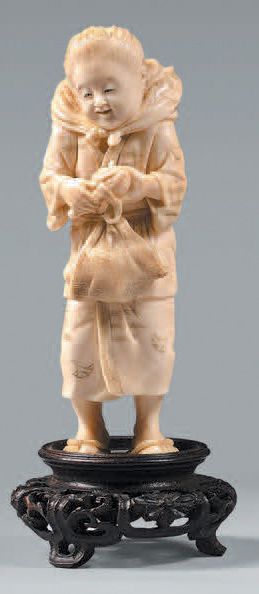 JAPON - Epoque MEIJI (1868-1912) Okimono en ivoire, enfant debout portant un baluchon...