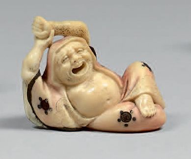 JAPON - Epoque MEIJI (1868-1912) Netsuke en ivoire partiellement teinté, Daruma allongé...