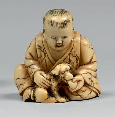 JAPON - Époque Edo (1603-1868), XVIIIe siècle Netsuke en ivoire, enfant assis nourrissant...