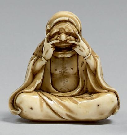 JAPON - Époque Edo (1603-1868), XIXe siècle Netsuke en ivoire, Daruma assis faisant...