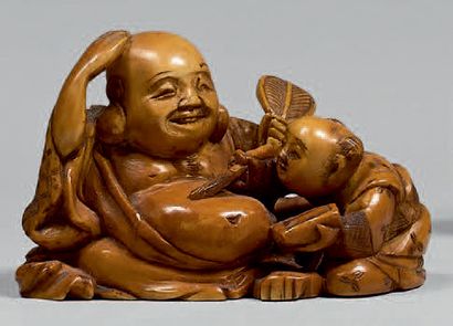 JAPON - Epoque MEIJI (1868-1912) Netsuke en ivoire teinté, Hotei assis tenant son...