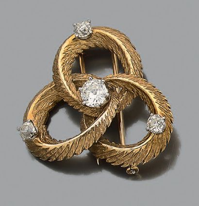 null Broche en or jaune 750 millièmes figurant trois anneaux gravés entrelacés ornée...