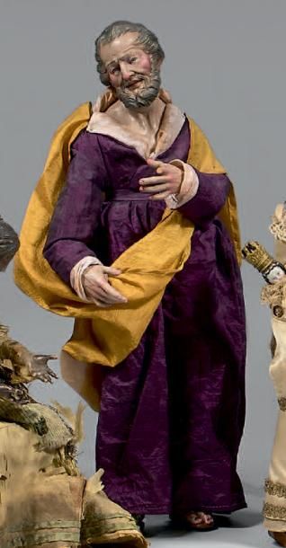 null Saint Joseph en robe violette et cape jaune en adoration en terre cuite polychrome.
(Petits...