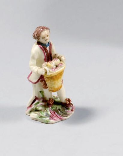 MENNECY (porcelaine tendre) STATUETTE DE JEUNE JARDINIER en pied tenant une corbeille...