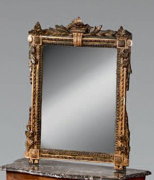 Miroir dans un cadre en bois sculpté et doré...