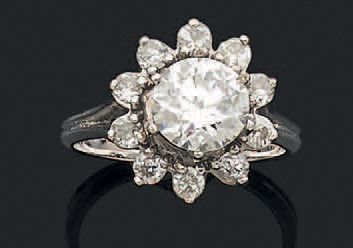 null Bague en or gris 750 millièmes ornée au centre d'un diamant rond de taille brillant...