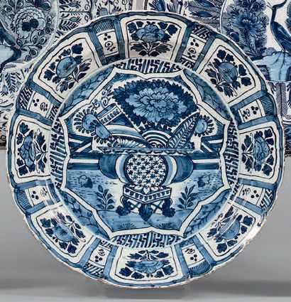 DELFT 
Plat rond à bord contourné décoré en camaïeu bleu au centre d'une vasque fleurie...