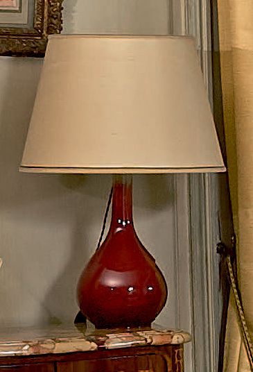 CHINE, vers 1900 Vase bouteille en porcelaine émaillée rouge flammé.
Monté en lampe.
Hauteur:...