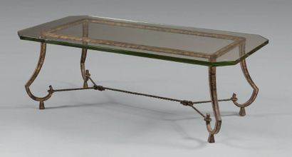 RAMSAY Table basse en fer forgé à patine dorée, plateau ovale
en verre reposant sur...
