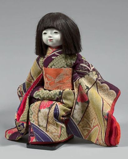 JAPON - XXe siècle Poupée de jeune fille assise en kimono, le visage en gofun.
Hauteur:...