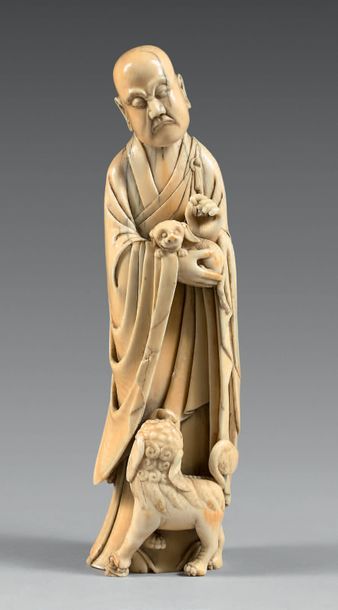CHINE - XVIIIe siècle Statuette en ivoire, luohan debout tenant un chiot dans ses...