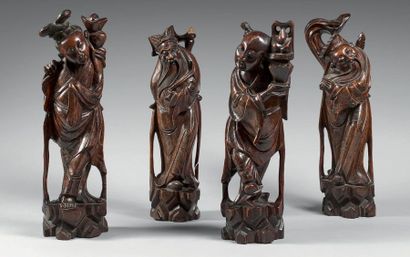 CHINE - XIXe siècle Quatre statuettes d'immortels debout en bois, tenant des ruyi,...