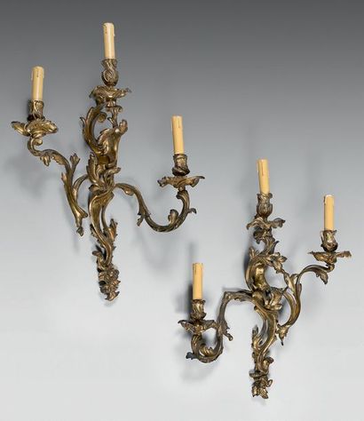 null Paire d'appliques rocaille en bronze doré à trois bras de lumière feuillagées.
Style...